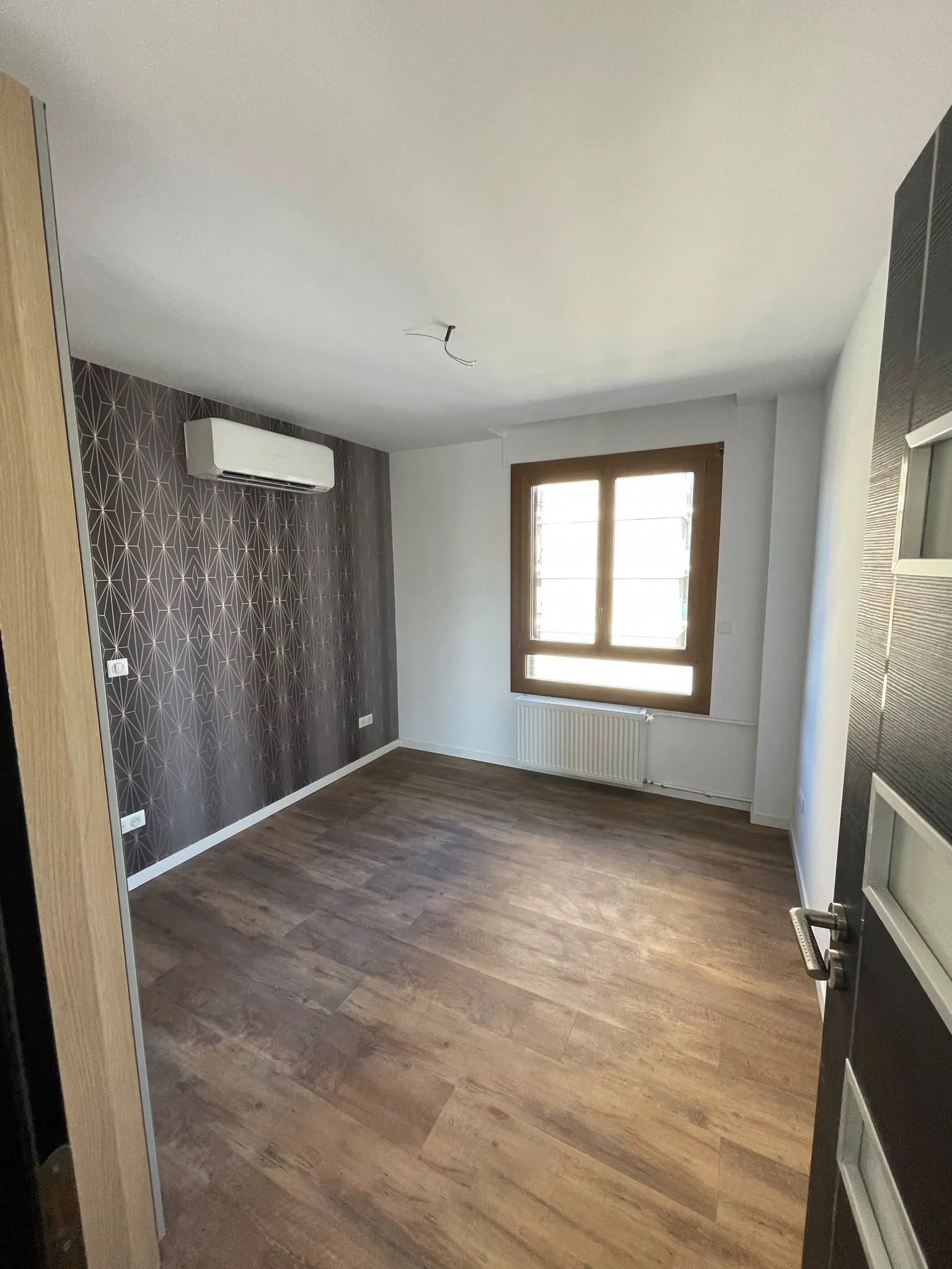 Chambre rénovée avec climatisation murale et parquet