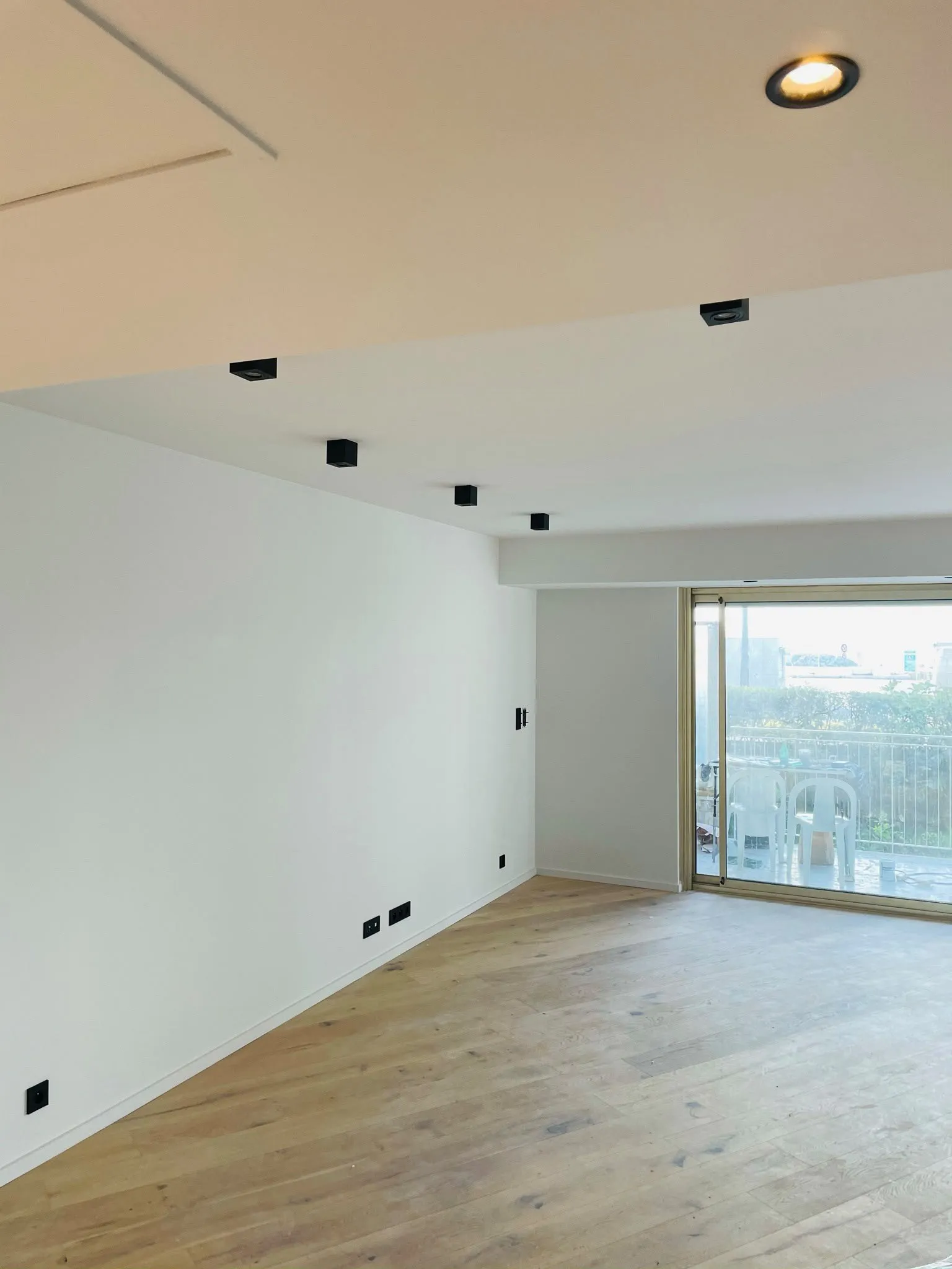 Séjour rénové avec spots encastrés au plafond et prises neuves