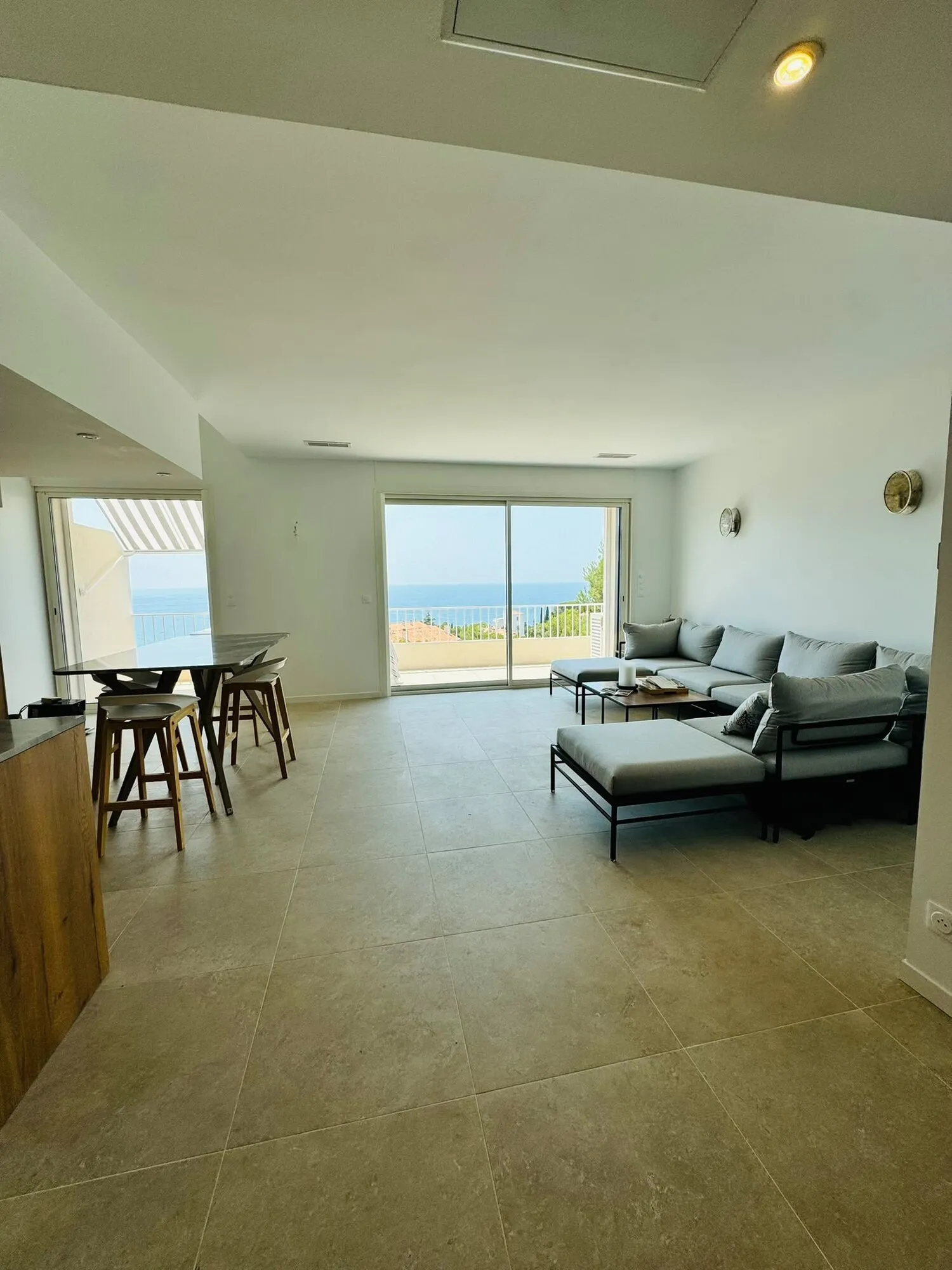 Séjour rénové avec carrelage grand format et vue sur la mer
